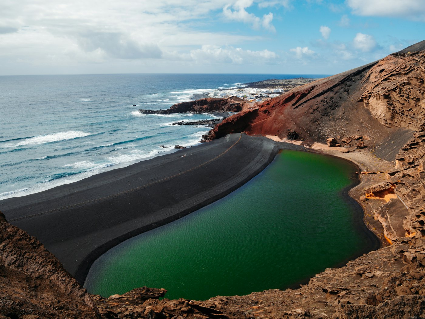 La laguna verde de El Golfo junto a la orilla de arena negra en la costa oeste de Lanzarote
