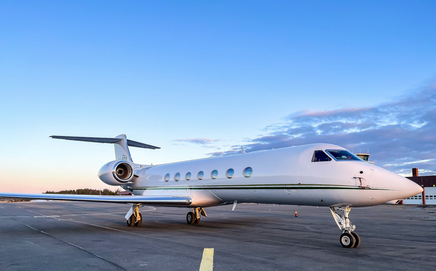 Un jet privado en la plataforma bajo un cielo despejado al atardecer
