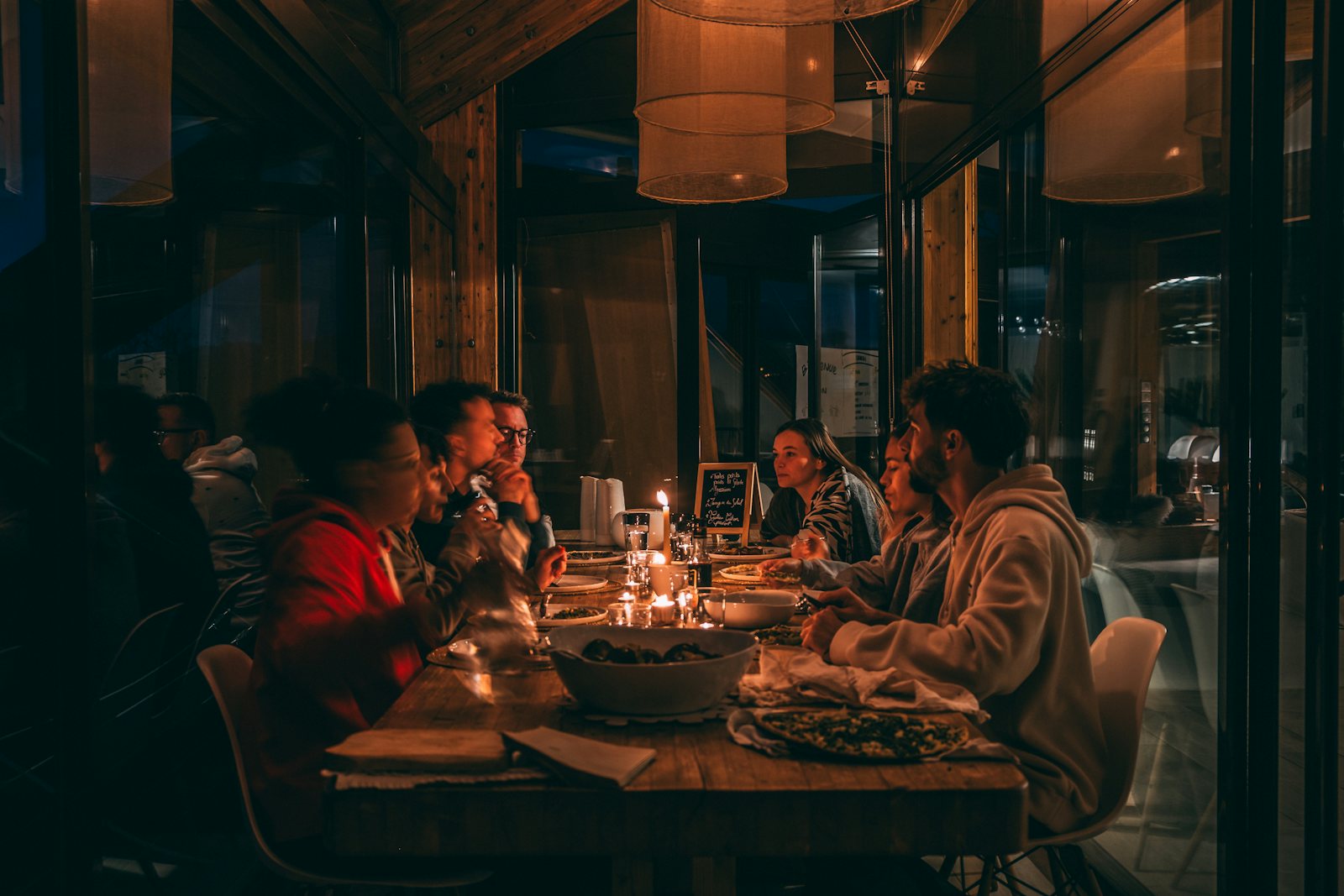 Invitados alrededor de una mesa a la luz de las velas en una cena privada